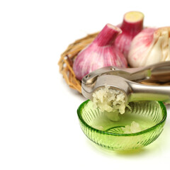 Garlic press and garlic on white background 