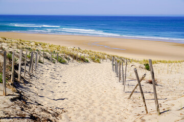 Chemin de sable accès à la plage mer avec clôture en bois en été