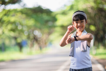 happy child girl running in the park in summer in nature. warm sunlight flare. asian little is running in a park. outdoor sports and fitness, exercise and competition learning for kid development.