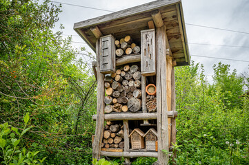 Wooden insect house in the garden. Bug hotel in natural environment. Insect hotel in Switzerland.