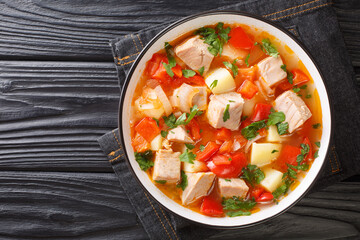 Marmitako Recipe for a Classic Basque Meal made of tuna fish, potatoes, tomatoes and pepper closeup in the plate on the table. Horizontal top view from above