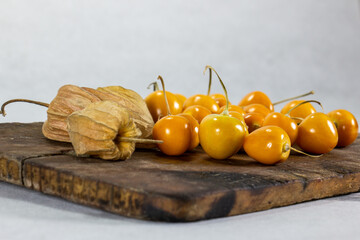 Fresh winter cherries, Physalis, Cape gooseberry, Aguaymanto, Uvilla, Peruvian fruit on a wooden base.