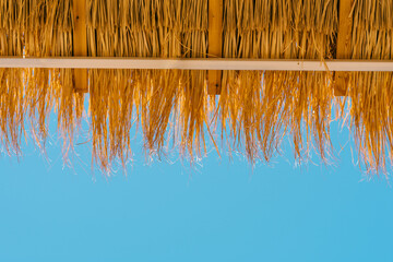Straw Beach Umbrella Against A Blue Sky.