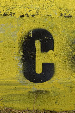 Black stencil letter on bright yellow background