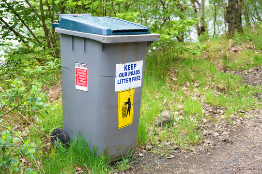 Keep roads litter free sign at roadside on wheelie bin