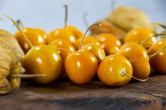 Fresh winter cherries, Physalis, Cape gooseberry, Aguaymanto, Uvilla, Peruvian fruit on a wooden base.