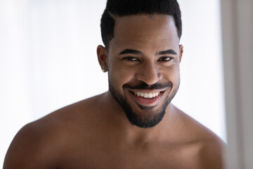 Close up portrait of attractive African American guy with stylish beard, piercing, white healthy...