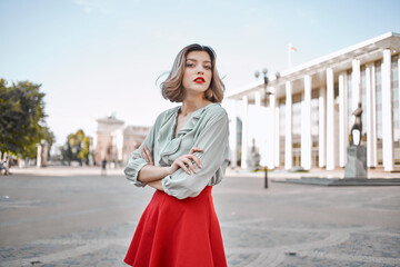 Fototapeta premium cheerful pretty woman in red skirt walking outdoors