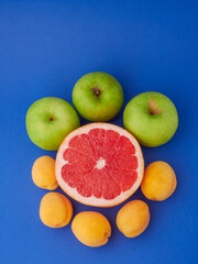 Fresh organic fruit on a blue background, space to copy.