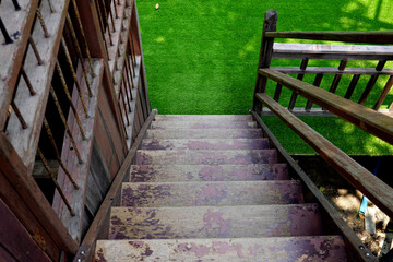 A wooden stairs leading a way down into the grass  