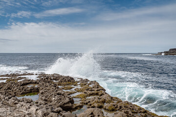 Ocean wave crushes on stone coastline of Inishmore, Aran Islands, County Galway, Ireland. Irish landscape. Cloudy sky