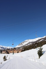 Snowy village on the top of the mountains with a chairlift crossing above the sky track in bariloche patagonia, la cathedral best skiing spot in south america