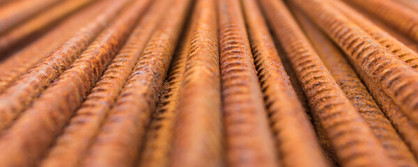 Wide banner with building construction materials - many rusted metallic long building rods.