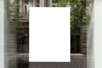 Mockup template with shop window and hanging large white paper sheet.