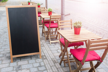 Mockup template with summer outside cafe seating setting place and blank black menu charcoal board.
