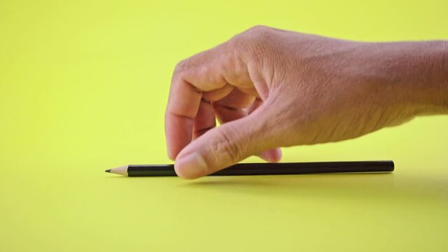 Pencil on business office yellow table and Business hand man hand picking a pencil from business table office background