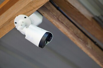 Concept : home security system. IP CCTV camera installed on wooden ceiling of house. Safety at home.
