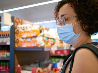 A woman wears a face mask while shopping in a supermarket