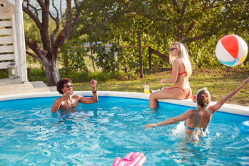 multiethnic group of friends having fun in the outdoor pool