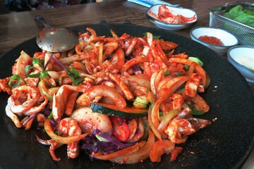 Delicious spicy korean rice cake on fried pan with side dishes
