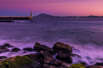 View of the Moroccan north coast and the port of Tarifa at sunset from Playa Chica beach, Tarifa, Cadiz Province, Andalusia, Spain © inigolaitxu