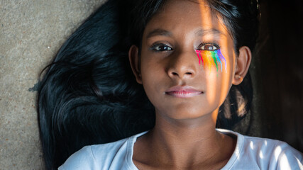 Close-up portrait of a young girl of LGBTQ community staring intensely at the camera with pattern...