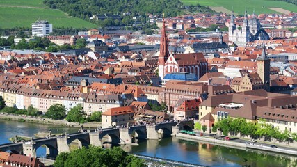 The picturesque panorama view of both banks of Wurzburg city along River Main. All houses were built with red roof. The picture shows Medieval Old Main Bridge and Wurzburg Cathedral.