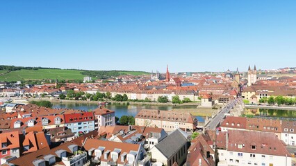 Fototapeta na wymiar The picturesque panorama view of both banks of Wurzburg city along River Main. All houses were built with red roof.