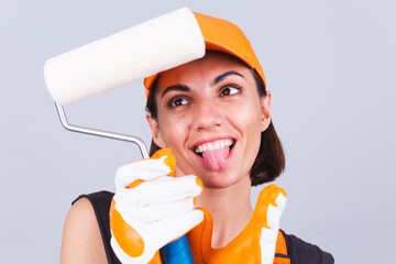 Painter woman with roller brush on gray background positive smiling happy