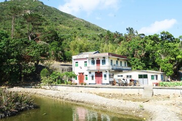 Fototapeta na wymiar A village house with auspicious red banners along the hiking trail from Tung Chung to Tai O