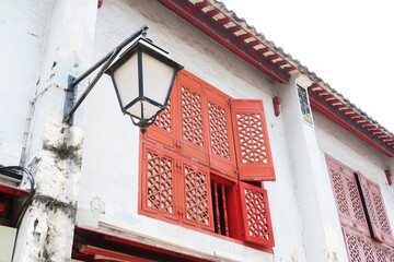 Historic building with red window and grey wall in Macau