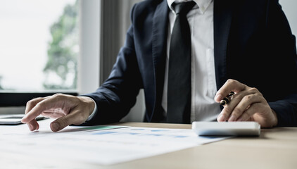 A businessman is reviewing information from finance documents to bring to department and partnership meetings, preparing monthly attendance information. Concept of financial management.