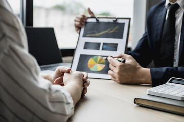 Two businessmen are meeting together on the topic of monthly finance, financial documents prepared by the finance department. Concept of financial management according to company policy.