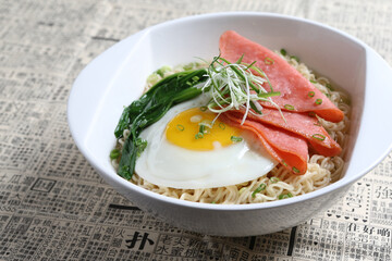 chef cook noodle mee soup with chicken ham and fried egg and vegetable asian halal menu