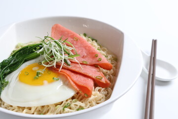 chef cook noodle mee soup with chicken ham and fried egg and vegetable asian halal menu
