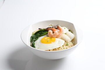 chef cook noodle mee soup with mixed seafood prawn, squid , fish, fried egg and vegetable asian halal menu