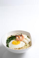 chef cook noodle mee soup with mixed seafood prawn, squid , fish, fried egg and vegetable asian halal menu