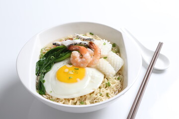 chef cook noodle mee soup with mixed seafood prawn, squid , fish, fried egg and vegetable asian halal menu
