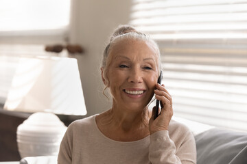 Smiling old 60s woman use modern smartphone talk speak on gadget with good quality mobile provider...
