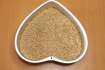 Organic jawar seeds isolated on wood background