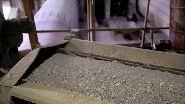 Close-up of a conveyor belt with gravel and crushed stone at a plant for the production of building materials. An industrial enterprise for the processing of cement. The territory of the cement plant.