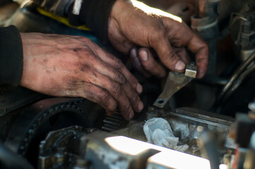 Fototapeta na wymiar Mechanic repairing car with dirty hands in oil