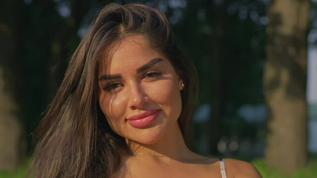 A brunette looks at the camera in the park.Red Helium 8K