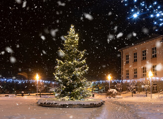 Christmas tree in Goleszów against a background of night sky and falling snow