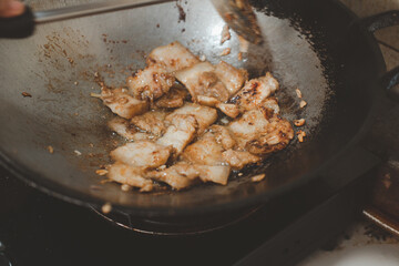 Cooking fried pork belly with garlic and pepper.