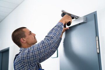 Handyman Installing And Fixing Door Closer - obrazy, fototapety, plakaty
