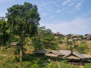 Fototapeta na wymiar Scenic landscape view of an Adi tribe traditional village with rice granaries in foreground in the mountains of Arunachal Pradesh, India