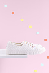 White women's sneakers on a light pink background. - 441722595