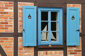 Fachwerkhaus mit blauem Fester mit Fensterläden in maritimer Region