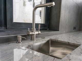 Stainless steel undermount kitchen sink and faucet with light marble countertop